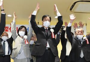 当選を決め、支援者らと万歳する鈴木力氏（中央）＝１０日午後１０時すぎ、燕市杣木