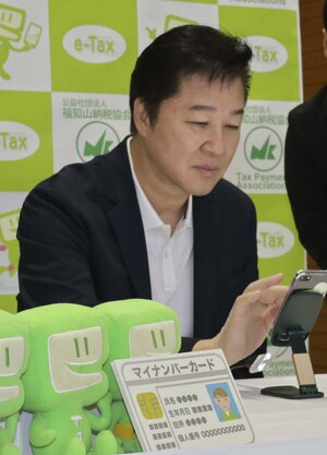 スマートフォンを使った確定申告を体験する川合俊一さん=1月18日、京都府福知山市