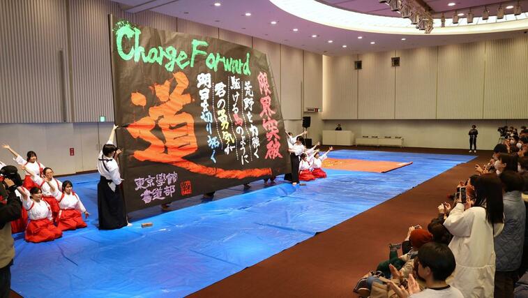 大きな筆を使ったパフォーマンスを披露する東京学館新潟高校の書道部員＝４日、新潟市中央区