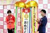 三条市で開かれた報告会でくす玉を割る高橋朋伽さん(左)と滝沢亮・三条市長=三条市役所