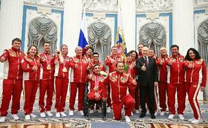 ミラノ・コルティナ冬季パラリンピックに出場したロシア選手らと写真に納まるプーチン大統領(右から5人目)=19日、モスクワ(ロシア大統領府提供・共同)