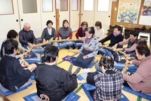 集落の安全を願う百万遍で、巨大な数珠を回す参加者=2月21日、胎内市菅田