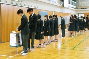 実際の選挙で使われている記載台や投票箱で模擬投票をする生徒たち=燕市吉田東町