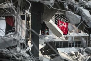 　イスラエル軍による停戦後の攻撃でがれきと化した建物の中で暮らすパレスチナ人家族＝３日、ガザ北部ガザ市（ゲッティ＝共同）