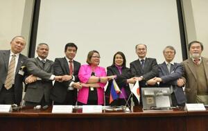 超小型衛星「DIWATA―1」の引き渡し式で、フィリピン関係者と記念撮影する高橋幸弘教授(右から2人目)ら=2016年1月、茨城県つくば市のJAXA筑波宇宙センター(JAXA提供)