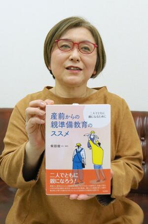 部分執筆した書籍を手に思いを語る「親なるサポート」代表の金子和保さん=三条市須頃2