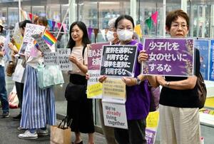 参政党の神谷代表の発言に抗議する集会でプラカードを掲げる人たち=12日午後、JR川崎駅前