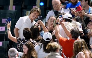 パリ五輪の体操会場でファンと写真に納まるトム・クルーズさん(左上)=7月、パリ(AP=共同)