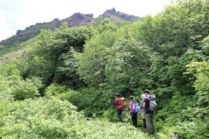 焼山噴火の犠牲者の発見場所近くで手を合わせる慰霊登山の参加者=7月27日、糸魚川市
