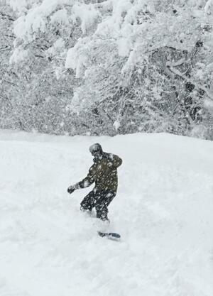 オープンした金谷山スキー場でスノーボードを楽しむ利用客＝２４日、上越市