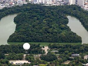 仁徳天皇陵古墳(奥)近くの大仙公園から浮かび上がったガス気球=3日午後、堺市(共同通信社ヘリから)