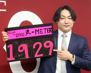 契約交渉を終え、通算安打数のボードを手に撮影に応じる巨人・丸=3日、東京都内