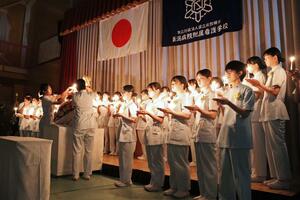 看護師になる決意を新たにした宣誓式の聖火継承=柏崎市赤坂町