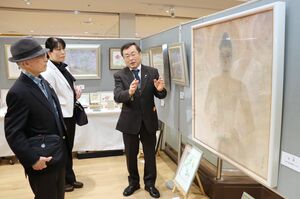 作品を解説する浦上義昭さん(右)=2日、長岡市城内町1のCoCoLo長岡