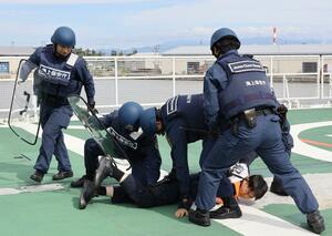 刃物を持った犯人役を取り押さえる海上保安官ら=新潟市中央区