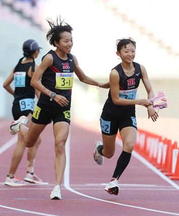 新潟明訓の１区石川桃子（左）が２区篠澤葉にタスキを渡す＝新潟市中央区