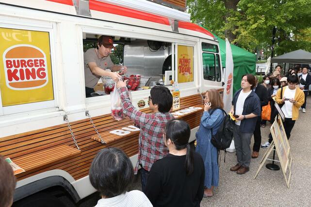 出店したバーガーキングのフードトラック。注文した商品を受け取る客＝＝１０日、新潟市中央区