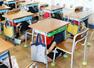 訓練で机の下にもぐり込む児童＝１６日、新潟市中央区の白山小学校