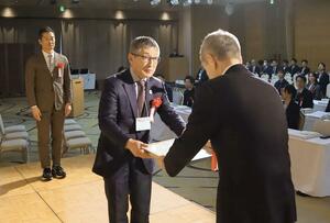 グランプリの賞状を受け取る菊水酒造の髙澤大介社長（中央）＝９日、新潟市中央区