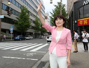 参院選新潟選挙区で初当選を果たし、歩行者やドライバーに手を振ってあいさつする打越さく良さん=22日午前8時前、新潟市中央区