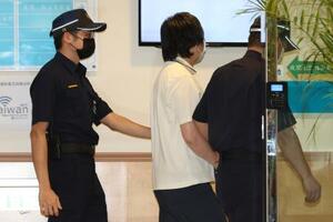判決公判に出廷するため裁判所に到着した陳力銘被告(中央)=27日、台湾・新北市(中央通信社=共同)