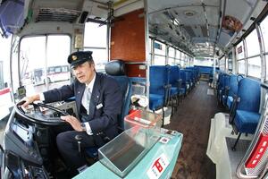 目﨑さんがハンドルを握る670号車。木張りの床からは腐食を防ぐ油の匂いがする=長岡市千秋2