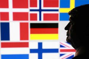 　トランプ米大統領のミニチュア像と、グリーンランドを巡り関税を課すとした対象８カ国の国旗（ロイター＝共同）