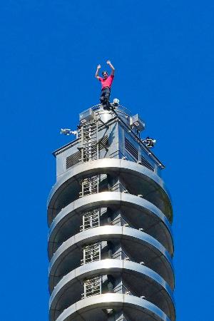 「台北101」を登り切って手を振るオノルドさん=25日、台北(中央通信社=共同)