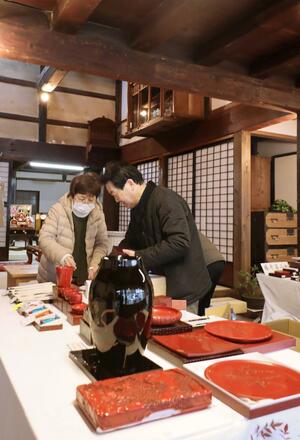 町屋で初めて開催する堆朱まつりに向け、準備を進める職人たち=3月18日、村上市大町