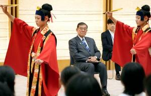沖縄県から訪れた小中学生「豆記者」らによる琉球舞踏を見る石破首相(中央)=30日午後、首相官邸