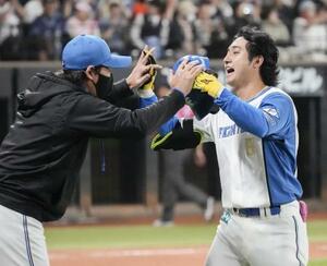 9回、サヨナラ二塁打を放ち新庄監督(左)に迎えられる日本ハム・浅間=エスコンフィールド