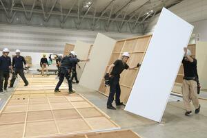 県展開幕に向け、展示パネルの設営を進める作業員=17日、新潟市中央区万代島の朱鷺メッセ
