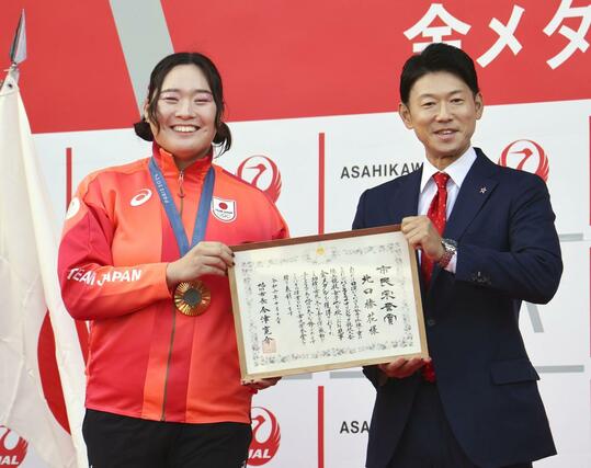 北海道旭川市の今津寛介市長（右）から市民栄誉賞を授与された陸上女子やり投げの北口榛花選手＝１３日午前、北海道旭川市