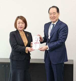 自社商品券の目録を手渡す原信の丸山三行社長（右）と、県フードバンク推進協議会の山下浩子理事長＝長岡市中之島