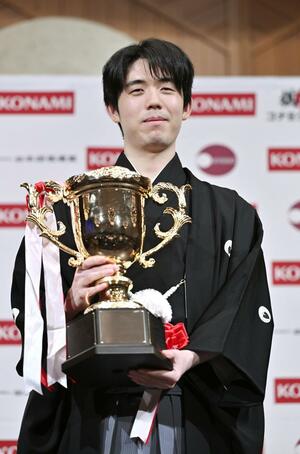 将棋の棋王就位式でトロフィーを手にする藤井聡太棋王=16日午後、東京都内のホテル