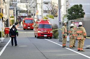 15日、火災のあった個室サウナ店周辺に駆けつけた消防隊員ら=東京都港区
