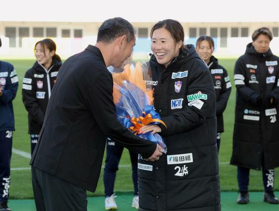 ホーム最終戦セレモニーでアルビレックス新潟の入江徹前監督から花束を受け取る川村優理＝５月９日、デンカビッグスワンスタジアム