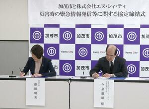 緊急情報発信に関する協定を結んだ藤田明美市長(左)とNCTの今泉道雄社長=加茂市役所