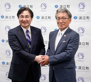 記者会見後に握手する東北大の冨永悌二学長(左)と福島県浪江町の吉田栄光町長=10日午後、同町