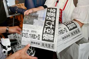 下野新聞社がJR宇都宮駅前で配布した特別紙面=12日午後
