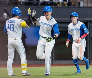 7回、勝ち越し2ランを放ち次打者水野(左)とタッチを交わす日本ハム・清宮幸。右は五十幡=エスコンフィールド