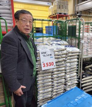 販売が始まり、5キロ入りの袋で倉庫に積まれた「国内産ブレンド米」=15日、長岡市の野上米穀