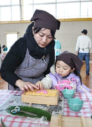 木箱に具材を敷き詰めて押しずしを作る参加者=2月2日、上越市吉川区