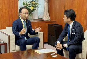 小泉進次郎農相(右)にコメの安定供給を要請する全国包装米飯協会の佐藤元会長=8日、農林水産省