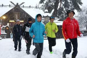 雪の中、神社を詣でながら走り初めをしたランナー＝１日、上越市寺町３
