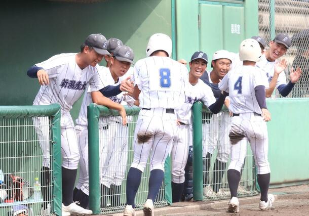 新潟産大付－村上桜ケ丘　二回、生還した走者２人を笑顔で迎える新潟産大付の選手たち＝新発田市五十公野