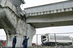 大阪府羽曳野市の南阪奈道路で、高架の壁を突き破って転落したダンプカー=7日午後1時47分