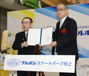 ネーミングライツ協定書に署名した村上市の高橋邦芳市長(右)とブルボンの吉田康社長=11日、村上市瀬波温泉3