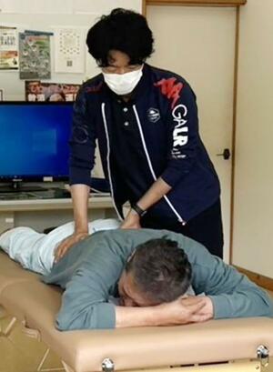 「ヘルスワーク」の一環で体の調子を整える理学療法士=佐渡市