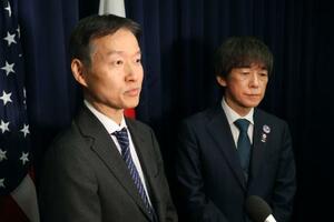 　日米共同記者会見の終了後、報道陣の取材に応じる柿田恭良文部科学審議官（左）＝４日、米ワシントン（共同）